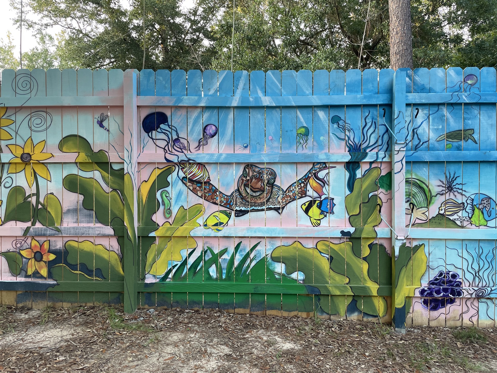 Underwater mural of a sea turtle among kelp and tropical fish, hand-painted by Tina Cozart